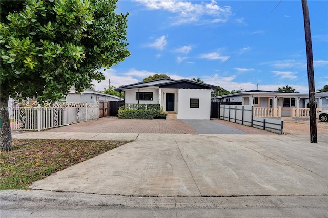 bungalow-style home featuring a fenced front yard and stucco siding