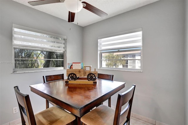 dining area with a ceiling fan and baseboards