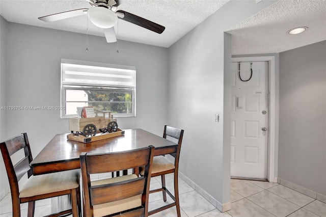 dining space with light tile patterned floors, a ceiling fan, and a textured ceiling
