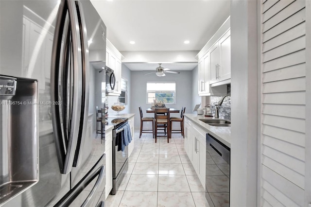 kitchen featuring a sink, light countertops, white cabinets, black appliances, and recessed lighting