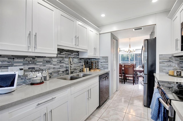kitchen featuring visible vents, freestanding refrigerator, white cabinets, a sink, and dishwasher