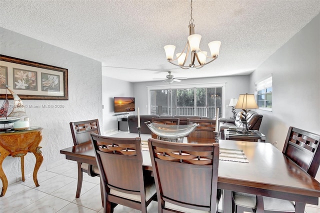 dining space featuring a textured ceiling, a textured wall, and ceiling fan with notable chandelier