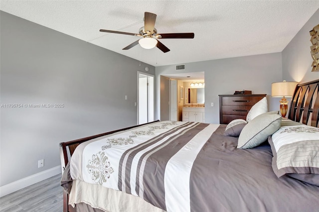 bedroom featuring visible vents, wood finished floors, baseboards, a textured ceiling, and a ceiling fan