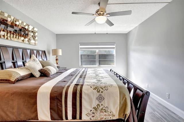 bedroom with baseboards, a ceiling fan, a textured ceiling, and wood finished floors
