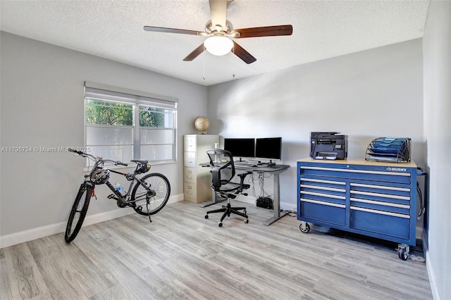 home office with baseboards, a ceiling fan, a textured ceiling, and wood finished floors