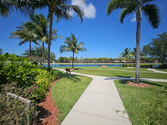 view of property's community with a lawn and a water view