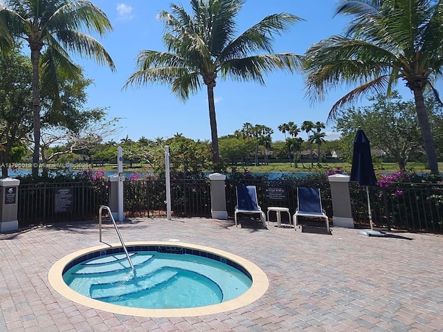 view of pool featuring a hot tub, a patio, and fence