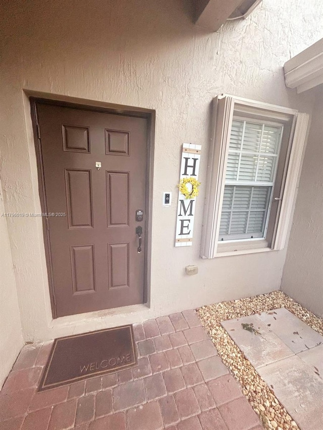 property entrance with stucco siding