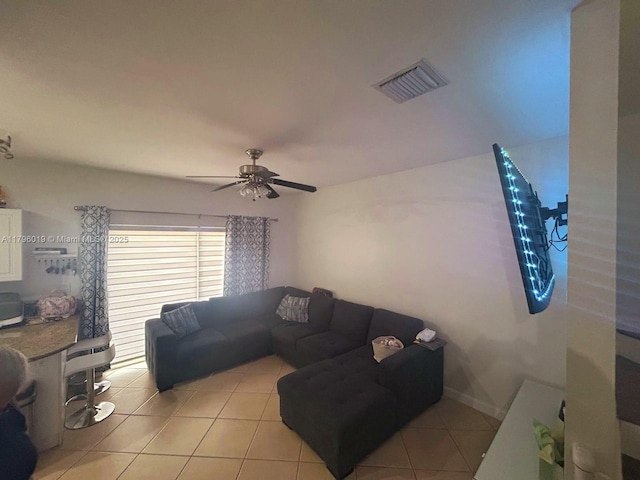 living room with light tile patterned flooring, a ceiling fan, and visible vents