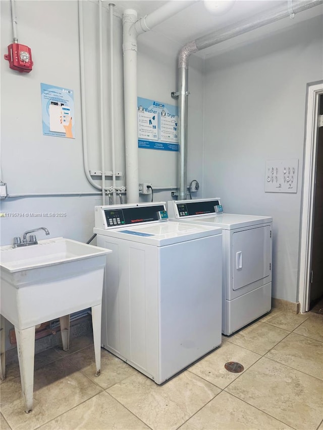 common laundry area with light tile patterned floors and washing machine and clothes dryer