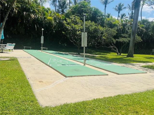 view of home's community with a lawn and shuffleboard