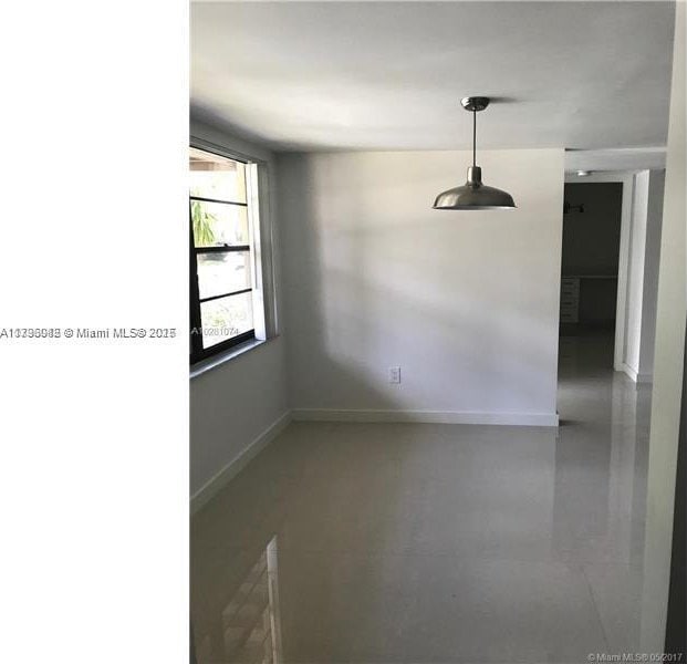 spare room with baseboards