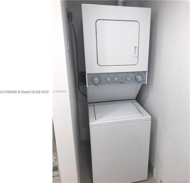 washroom with laundry area and stacked washing maching and dryer