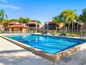 community pool with fence and a patio area