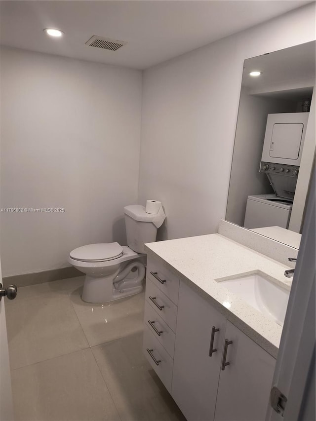 20841 San Simeon Way Unit 104, Miami, FL 33179 - bathroom featuring stacked washer / dryer, toilet, vanity, tile patterned floors, and recessed lighting