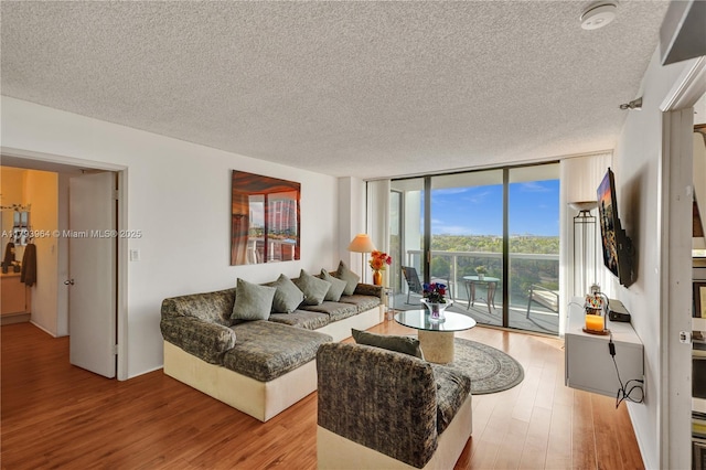 20505 E Country Club Dr Unit 732, Aventura, FL 33180 - living room with light wood-style floors, a textured ceiling, and a wall of windows