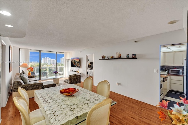 20505 E Country Club Dr Unit 732, Aventura, FL 33180 - dining room with a textured ceiling, wood finished floors, recessed lighting, and a wall of windows