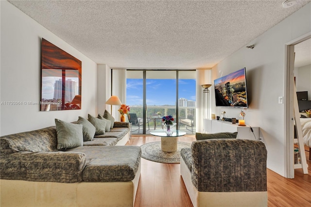 20505 E Country Club Dr Unit 732, Aventura, FL 33180 - living room with a wall of windows, light wood-style flooring, and a textured ceiling