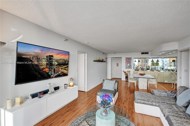 20505 E Country Club Dr Unit 732, Aventura, FL 33180 - living room with a textured ceiling and light wood-style flooring