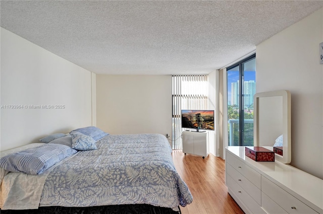 20505 E Country Club Dr Unit 732, Aventura, FL 33180 - bedroom with a wall of windows, light wood-style floors, and a textured ceiling