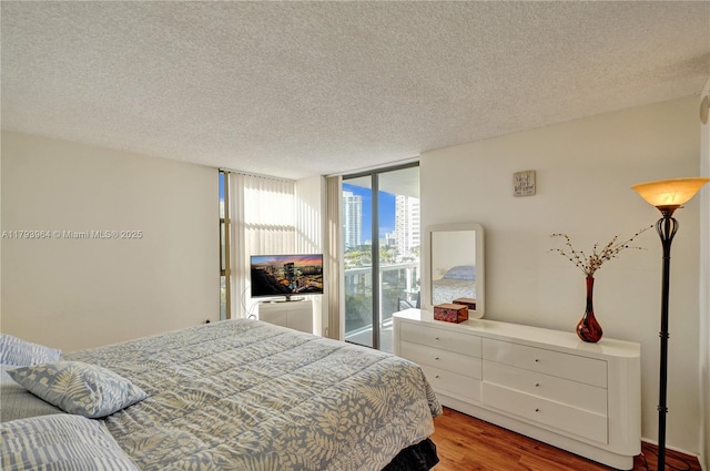 20505 E Country Club Dr Unit 732, Aventura, FL 33180 - bedroom featuring wood finished floors, a textured ceiling, and expansive windows