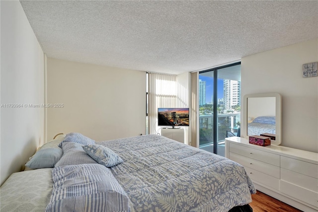 20505 E Country Club Dr Unit 732, Aventura, FL 33180 - bedroom featuring floor to ceiling windows, a textured ceiling, and wood finished floors