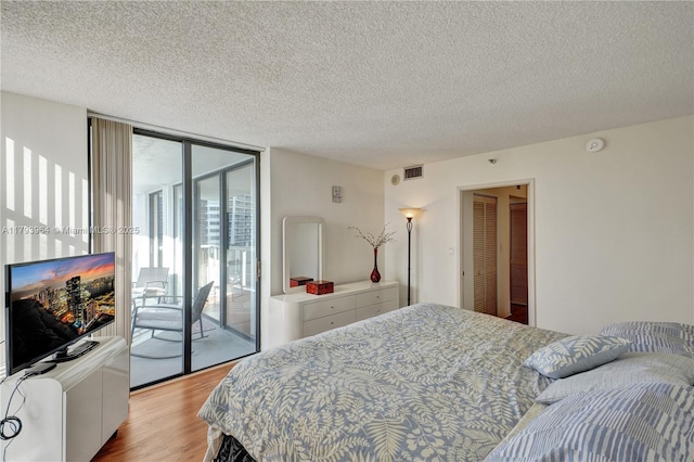 20505 E Country Club Dr Unit 732, Aventura, FL 33180 - bedroom with access to outside, light wood-style flooring, a textured ceiling, and floor to ceiling windows