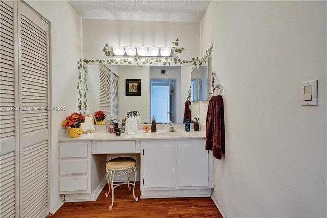 20505 E Country Club Dr Unit 732, Aventura, FL 33180 - bathroom featuring wood finished floors, a closet, vanity, and a textured ceiling