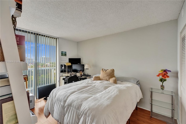 20505 E Country Club Dr Unit 732, Aventura, FL 33180 - bedroom with access to outside, a desk, wood finished floors, a textured ceiling, and baseboards