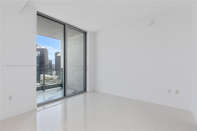 empty room featuring a view of city and floor to ceiling windows