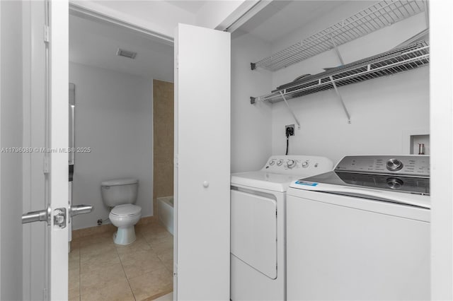 laundry area with washing machine and clothes dryer, laundry area, visible vents, and light tile patterned floors