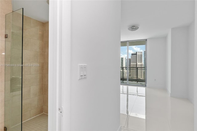 hallway with a wall of windows and tile patterned floors