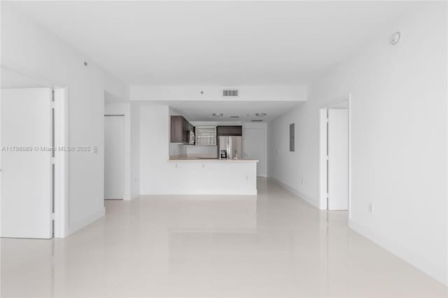unfurnished living room featuring visible vents and baseboards