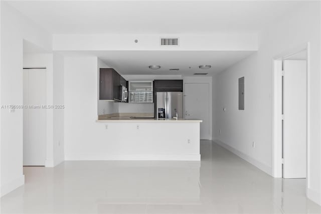 unfurnished living room featuring visible vents, baseboards, and electric panel