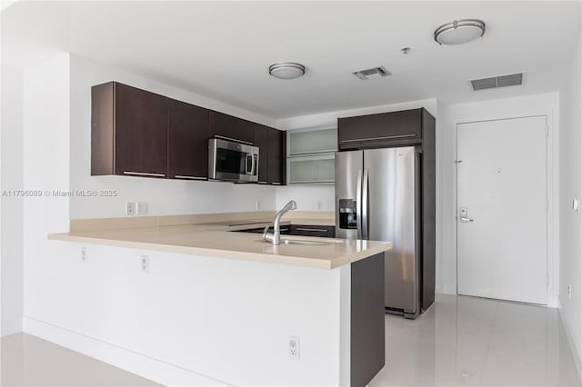 kitchen featuring light countertops, appliances with stainless steel finishes, a peninsula, and visible vents