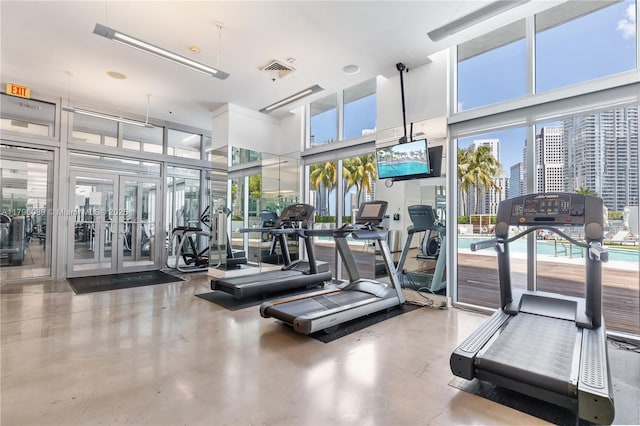 exercise room featuring visible vents and a towering ceiling