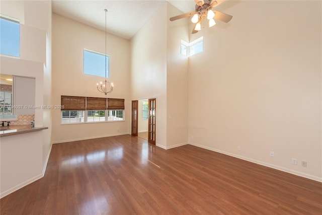 504 Bedford Ave, Weston, FL 33326 - unfurnished living room with a towering ceiling, a chandelier, wood finished floors, ceiling fan, and baseboards