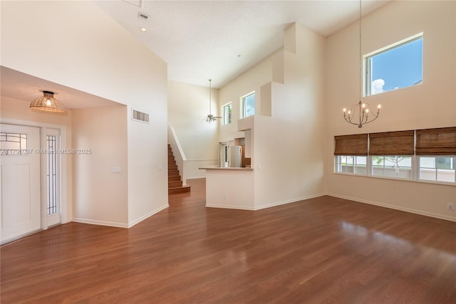 504 Bedford Ave, Weston, FL 33326 - unfurnished living room featuring a towering ceiling, a chandelier, wood finished floors, stairs, and baseboards