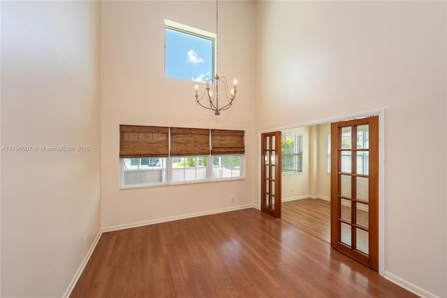 504 Bedford Ave, Weston, FL 33326 - empty room featuring a chandelier, wood finished floors, french doors, baseboards, and a towering ceiling