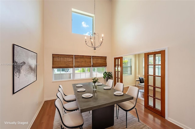 504 Bedford Ave, Weston, FL 33326 - dining space featuring a high ceiling, wood finished floors, a chandelier, and healthy amount of natural light