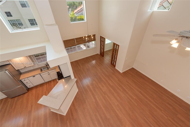 504 Bedford Ave, Weston, FL 33326 - unfurnished living room with a towering ceiling, wood finished floors, and baseboards
