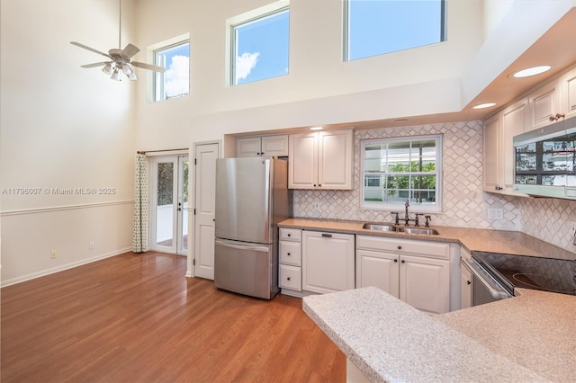 504 Bedford Ave, Weston, FL 33326 - kitchen with appliances with stainless steel finishes, a high ceiling, light wood-type flooring, backsplash, and light countertops