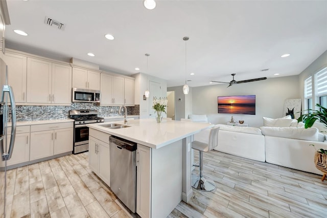 kitchen featuring visible vents, appliances with stainless steel finishes, a sink, and light wood-style flooring
