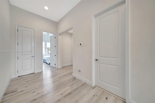 interior space featuring recessed lighting, baseboards, and light wood finished floors