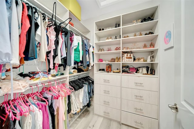 walk in closet with wood finished floors