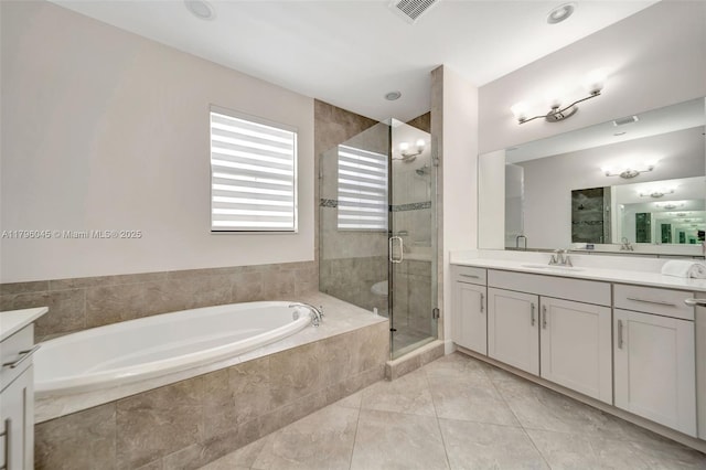 bathroom with visible vents, a shower stall, a garden tub, and vanity