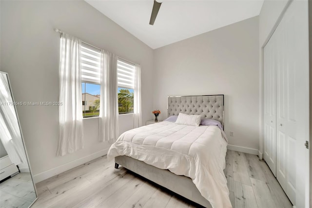 bedroom featuring light wood-type flooring, a ceiling fan, baseboards, and a closet
