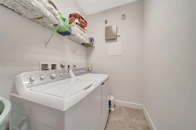 laundry area with baseboards, laundry area, and washer and clothes dryer