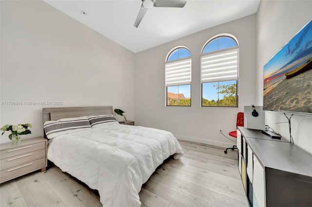 bedroom featuring baseboards, a ceiling fan, and light wood-style flooring
