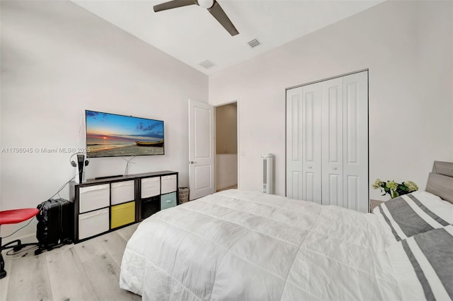 bedroom featuring ceiling fan, visible vents, wood finished floors, and a closet